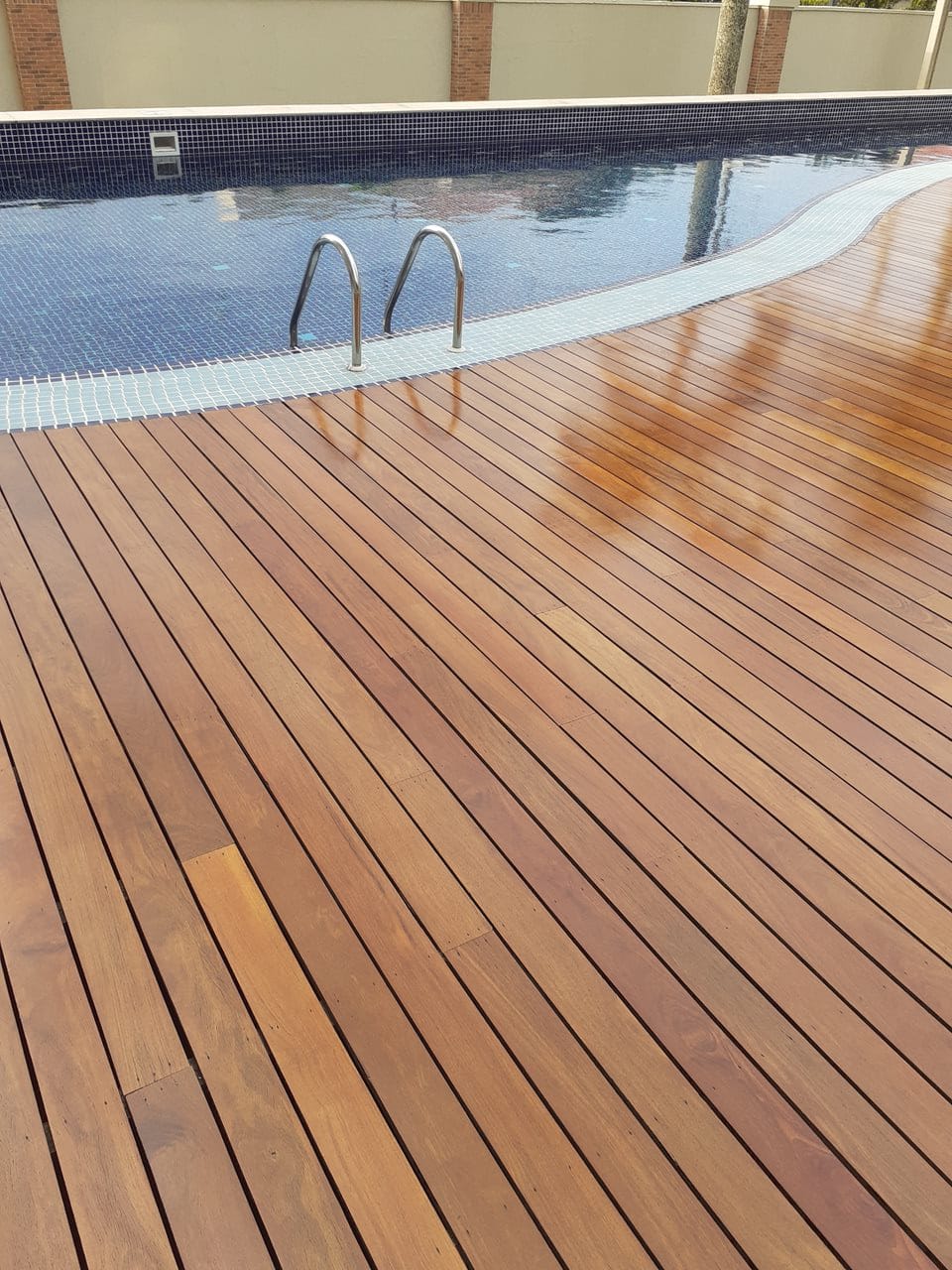 Detalhe de deck de madeira tratado próximo à piscina