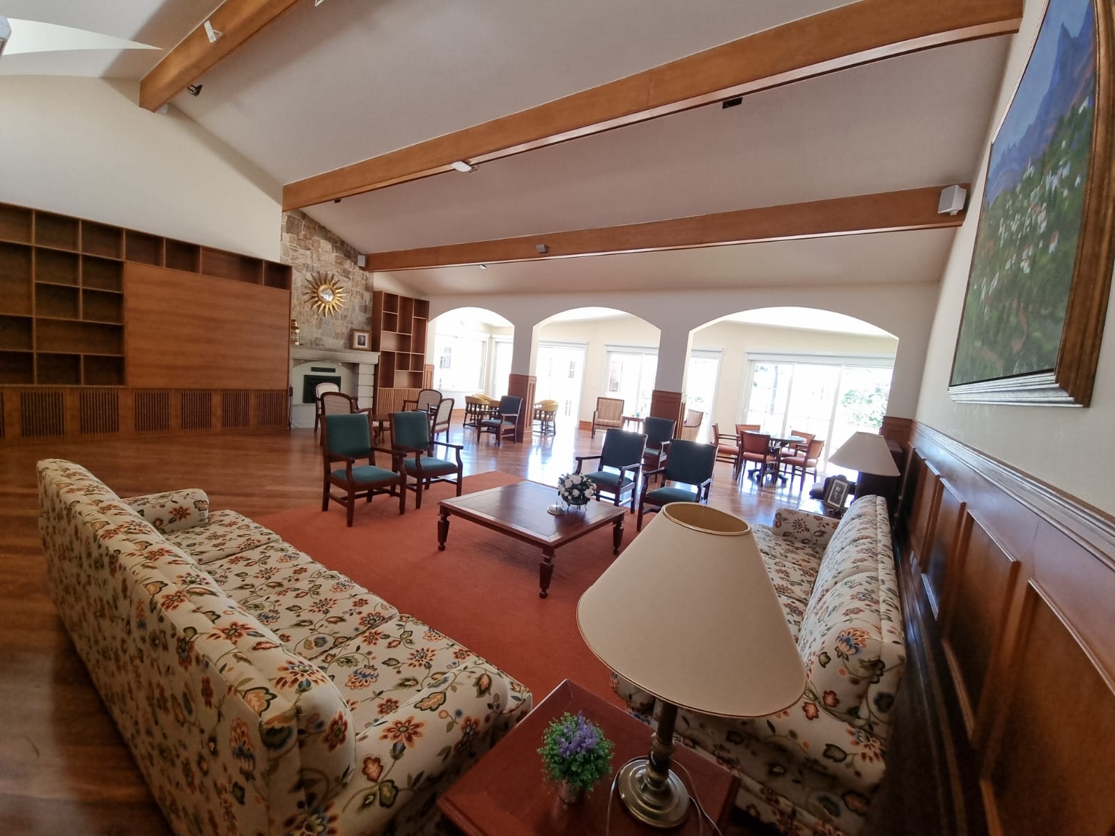 Sala ampla com piso de madeira restaurado e cadeiras